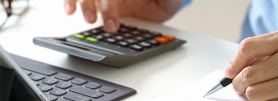 calculator, computer, and person holding a pen