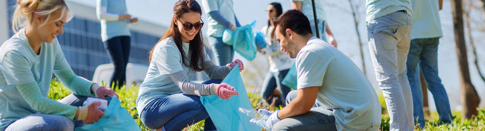 students in blue shirts cleaning litter and recycling