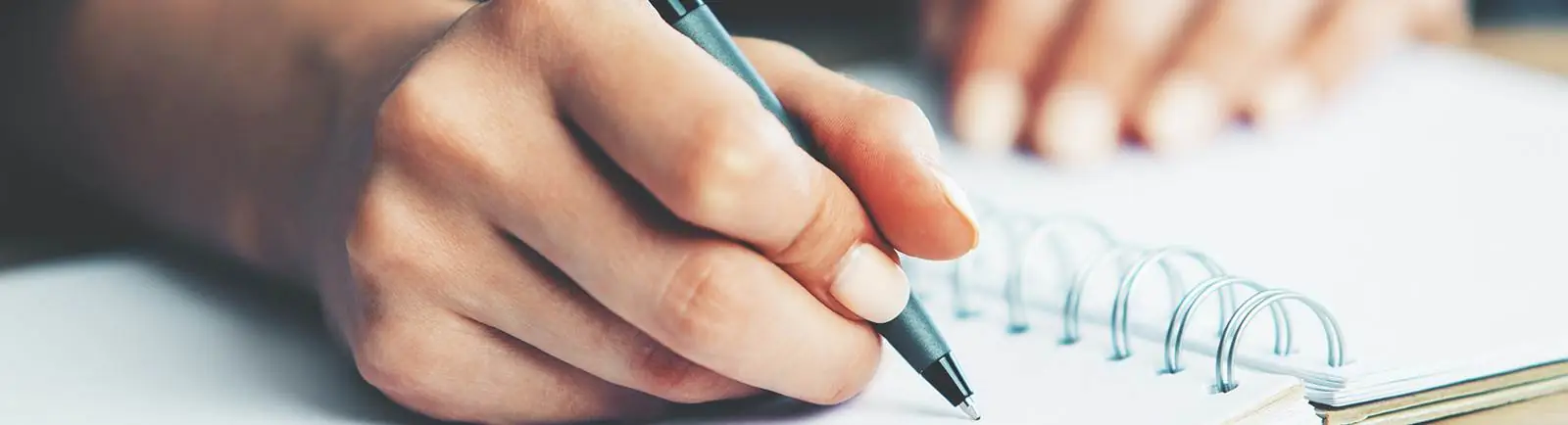 Close up of a hand writing in a notebook