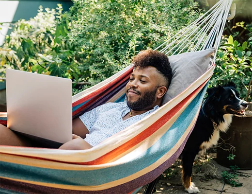 Student in Hammock with Dog