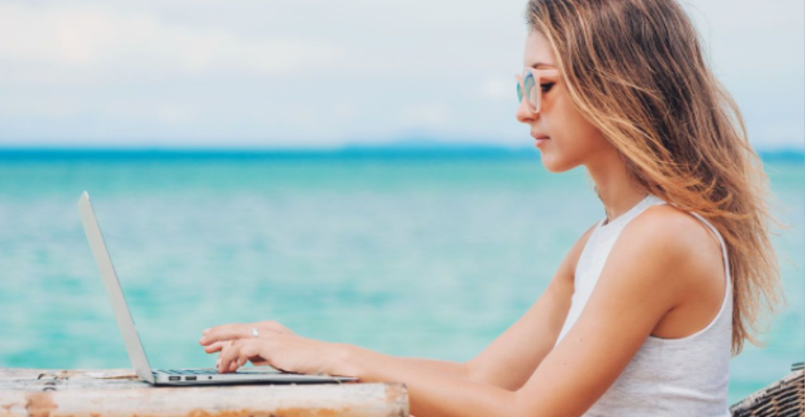 woman on laptop at beach