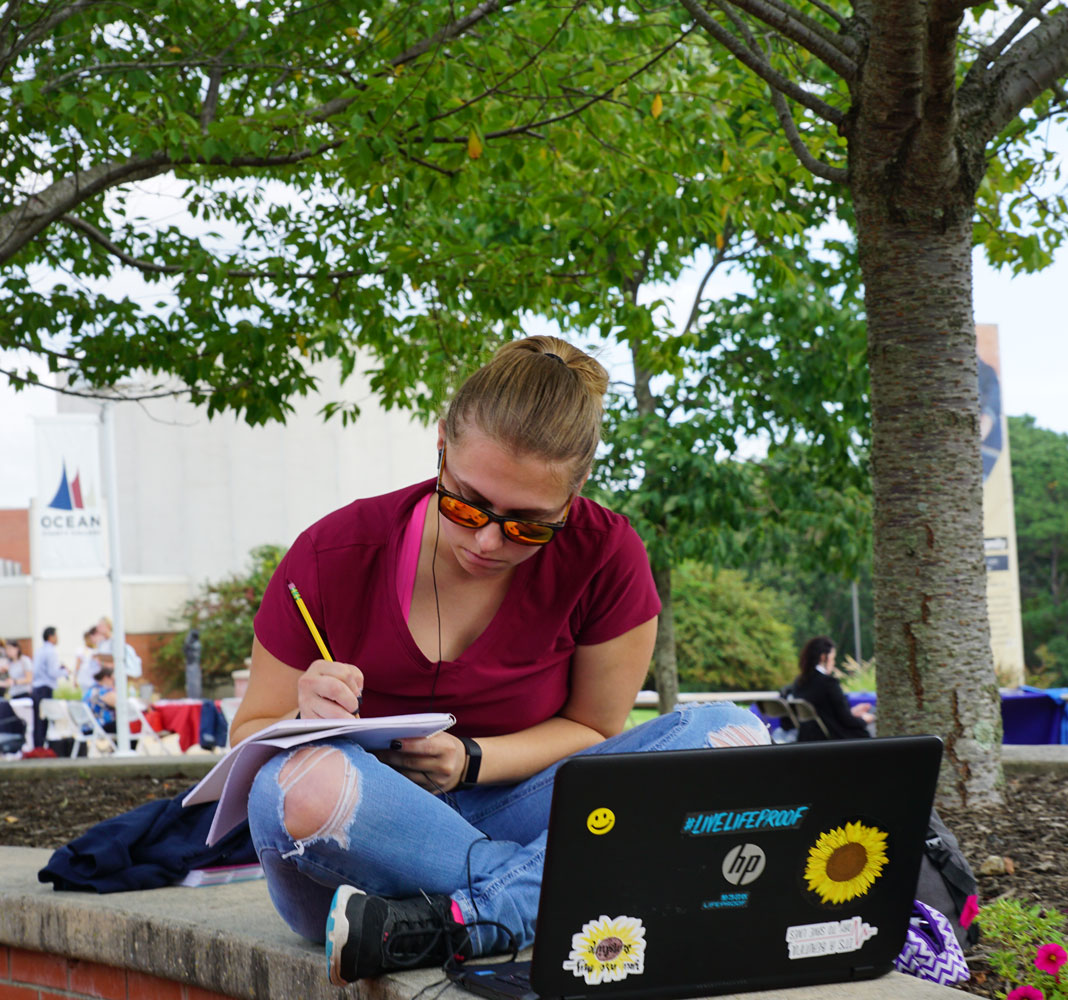 2018-10-02_Transfer-Fair-47 girl using a laptop and notebook sitting on OCC's campus