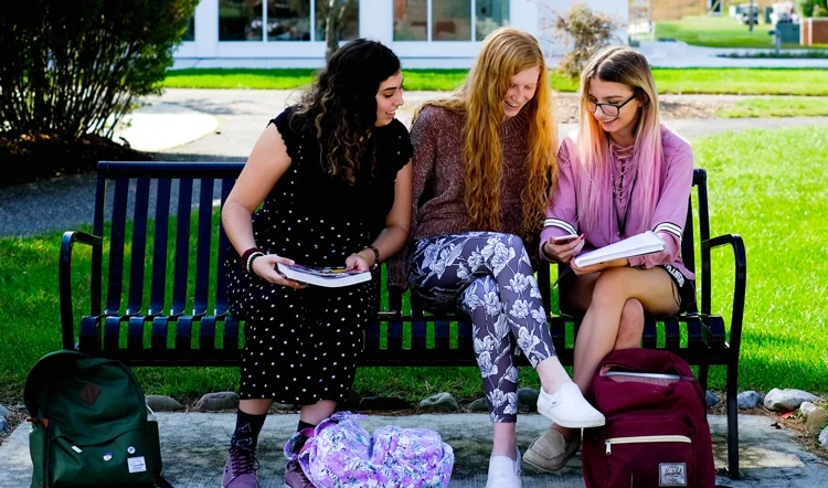 ocean.edu three female students studying on a bench on camp at Ocean County College