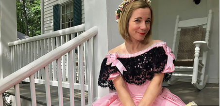 a woman sitting on a porch in a pink Civil War era dress