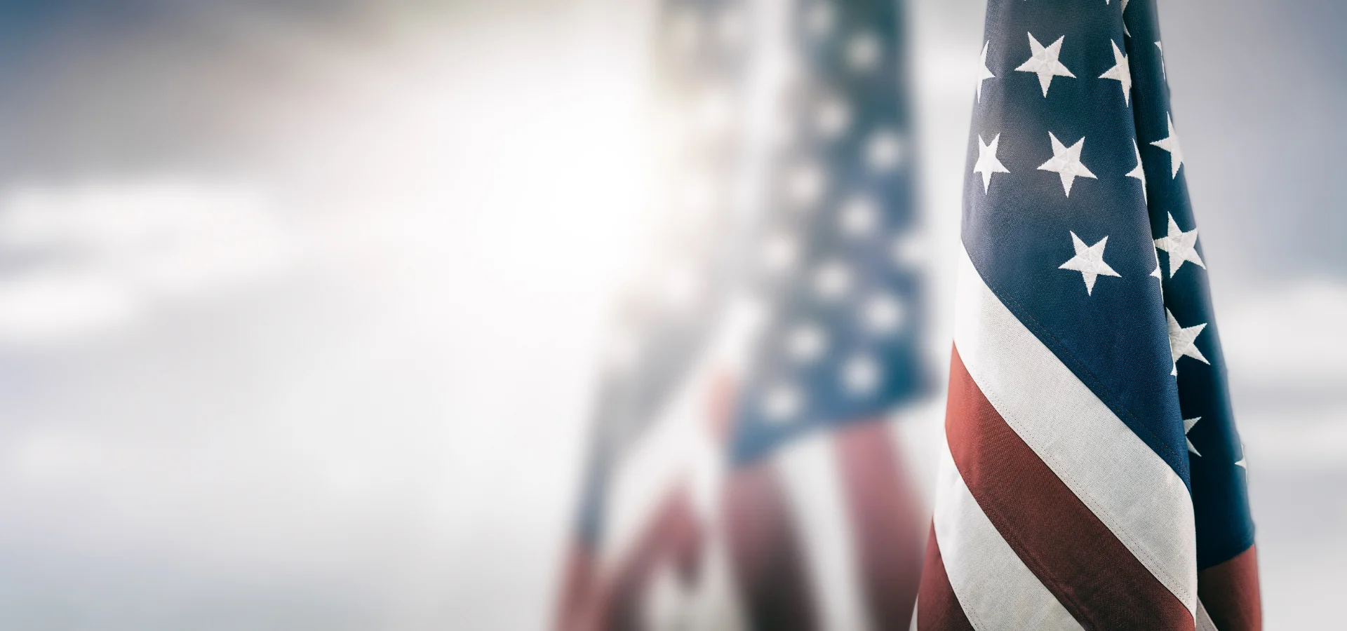 small american flags lined up with a bright light shining on them