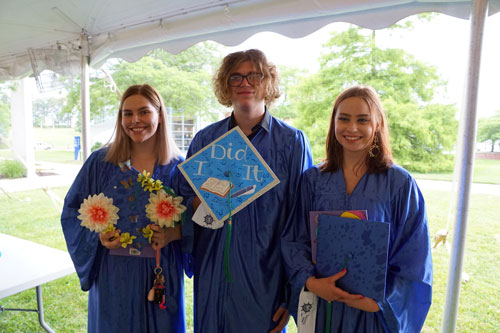 three students posing with their cap at the Ocean Achievement center graduation