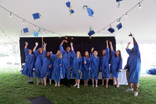 students tossing their caps at the Ocean County Achievement center graduation