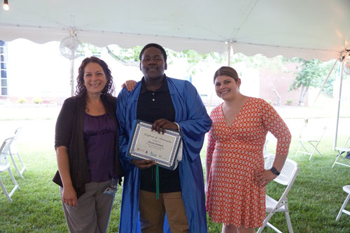 student with program facilitators at the Ocean Achievement center graduation