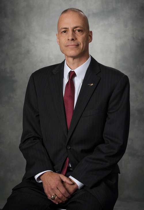 OCC alumni Gregg Bauer professional portrait with grey background