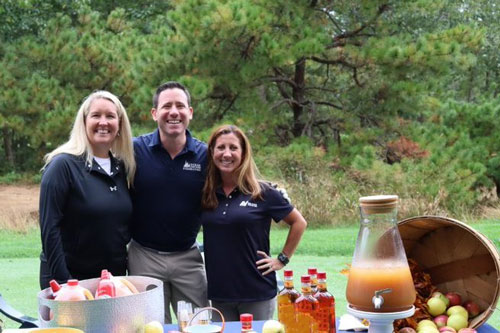 O.C.C. staff Ken, Alison, and Jessica at the apple cider station on the golf course at the 20th annual O.C.C. foundation golf classic