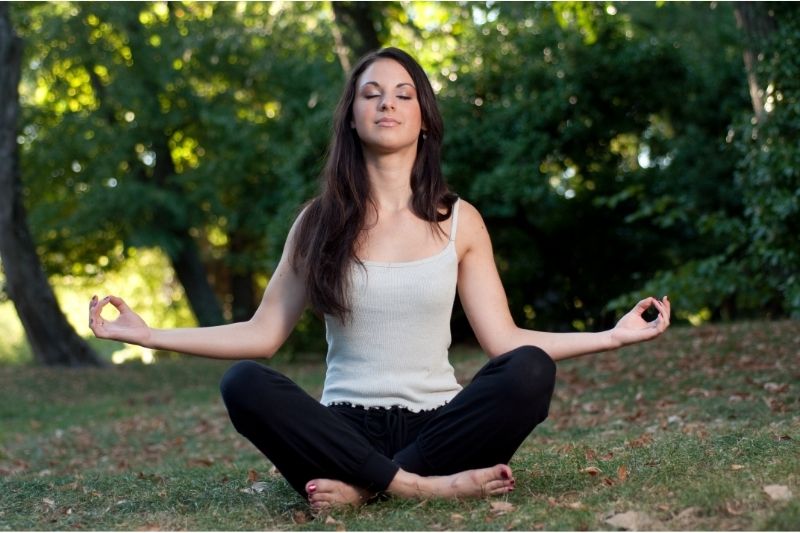 woman sitting outside meditating