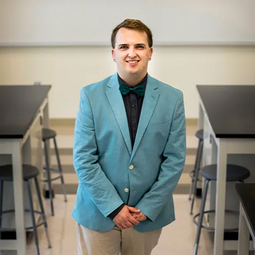 Austin Greitz posing for an image in a classroom