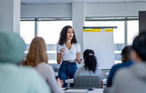 Teacher standing in front of class giving lecture to students