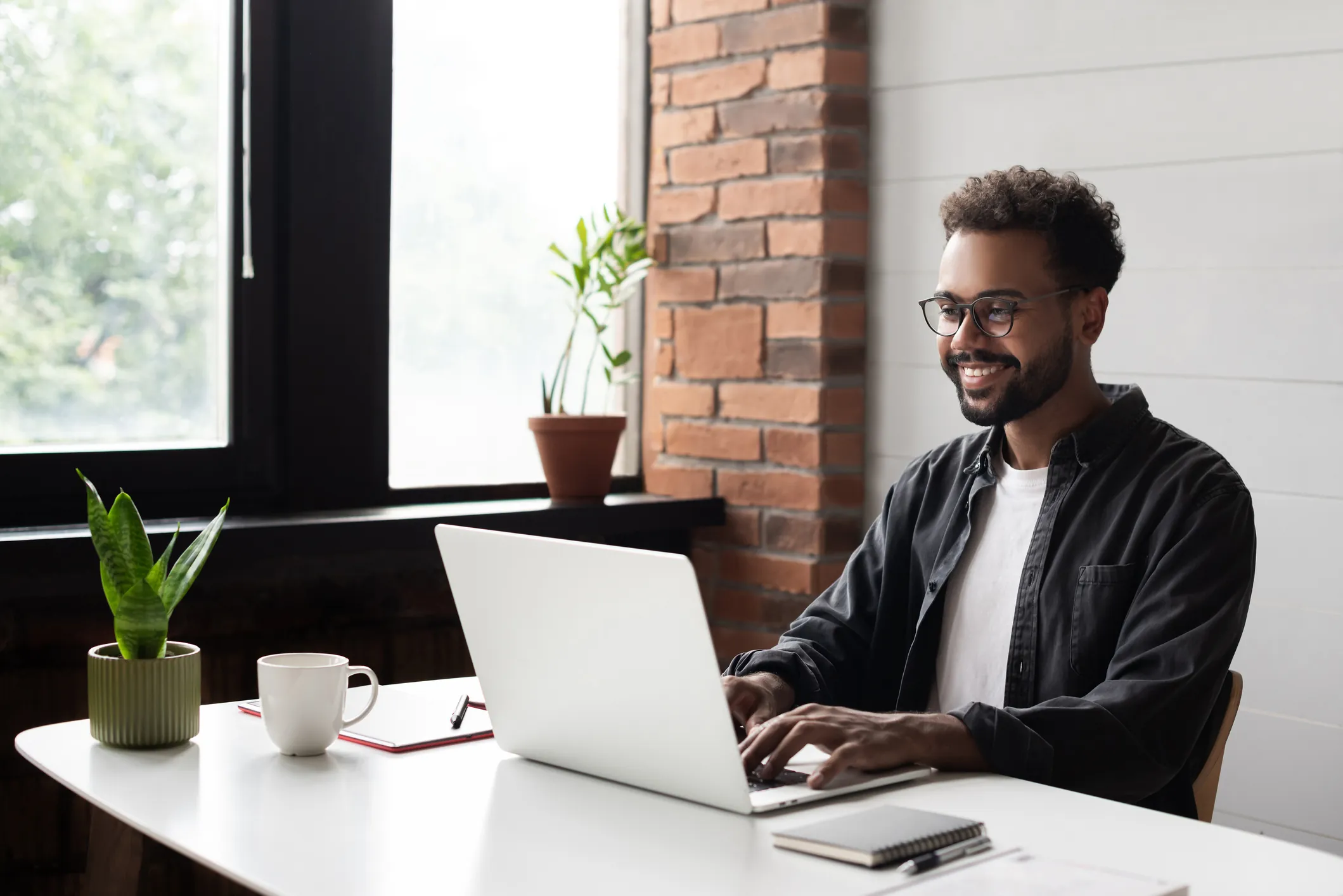 man sitting at desk working on laptop