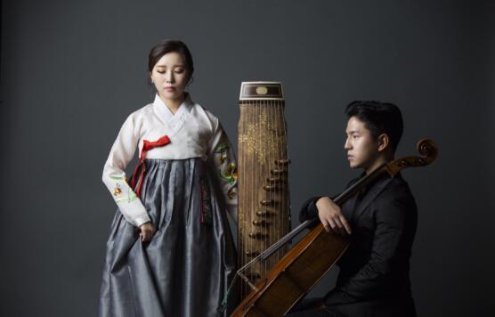 2 Individuals posing with their instruments, black background