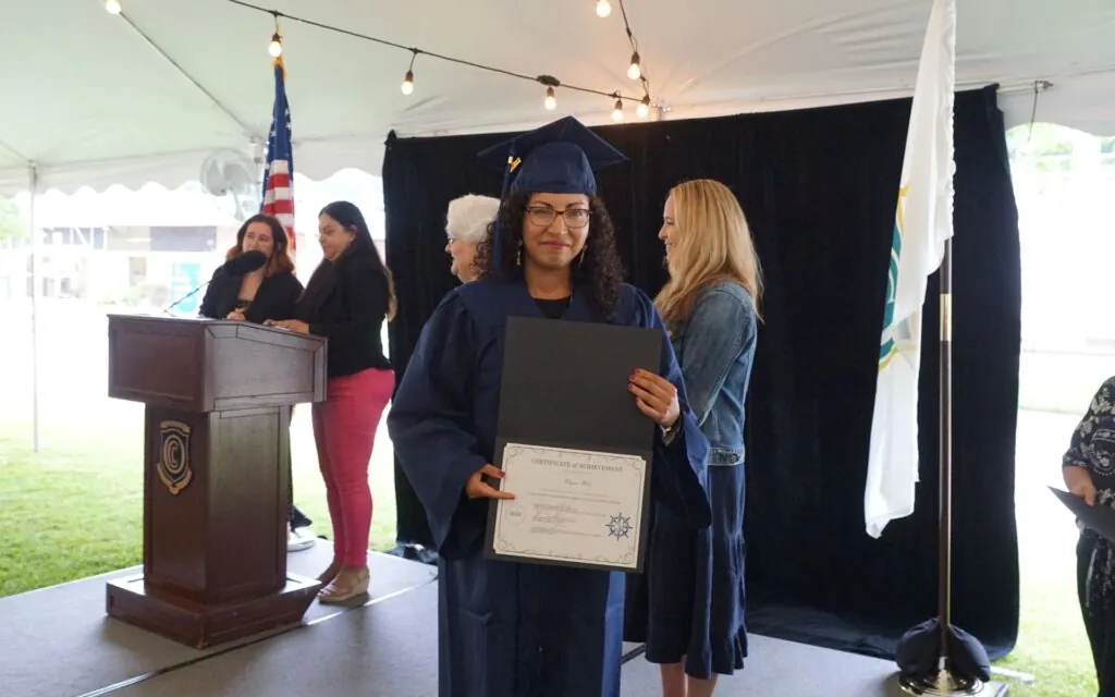 Woman showing her diploma at graduation