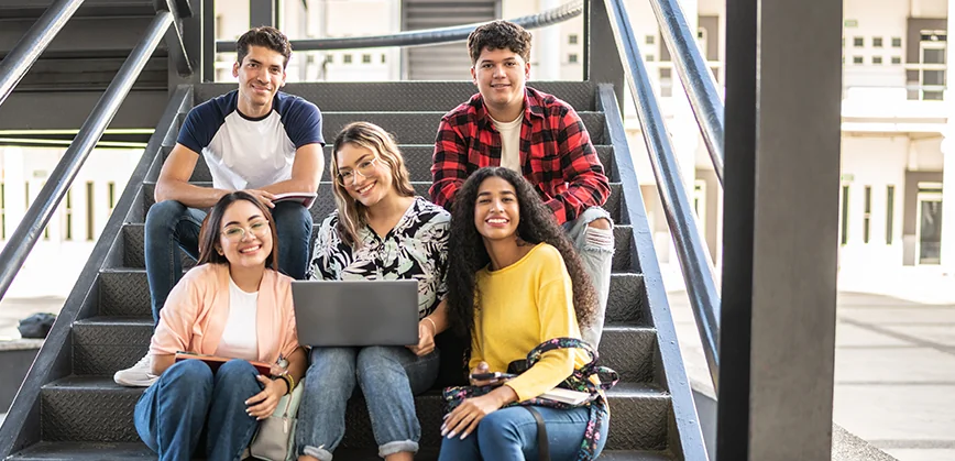 students sitting on steps with laptop