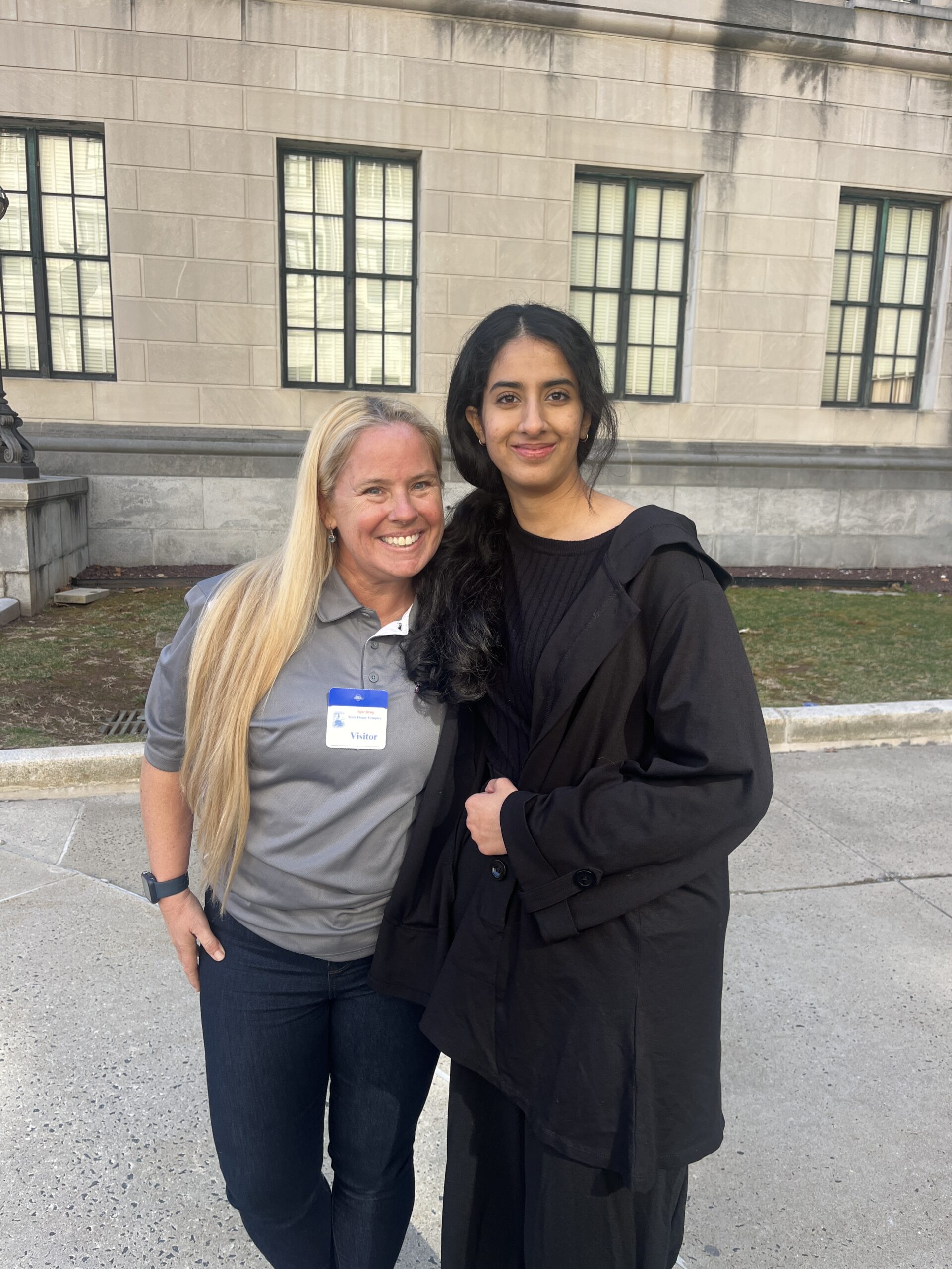 Two students posing in front of the NJ Statehouse