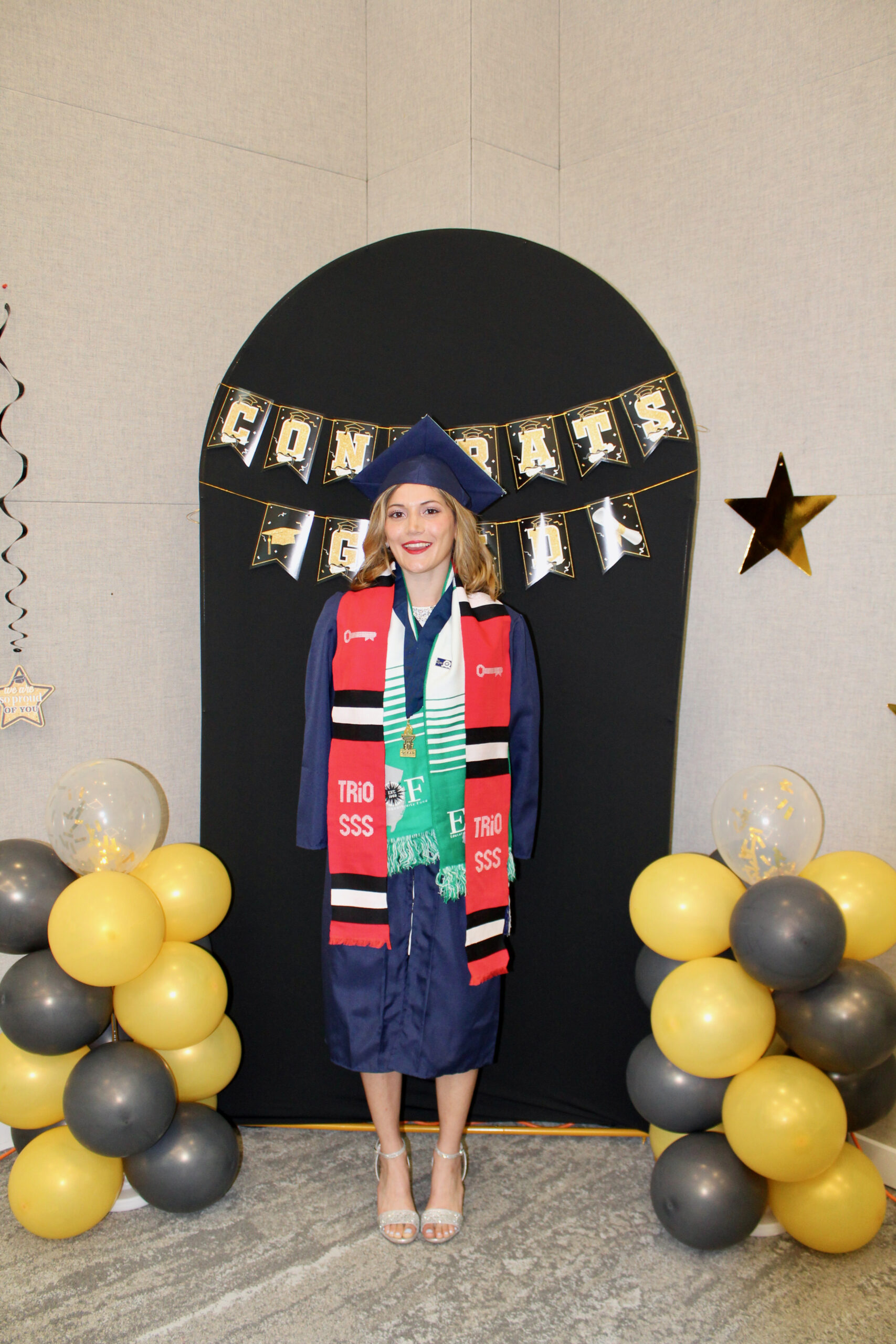A student posing in graduation regalia