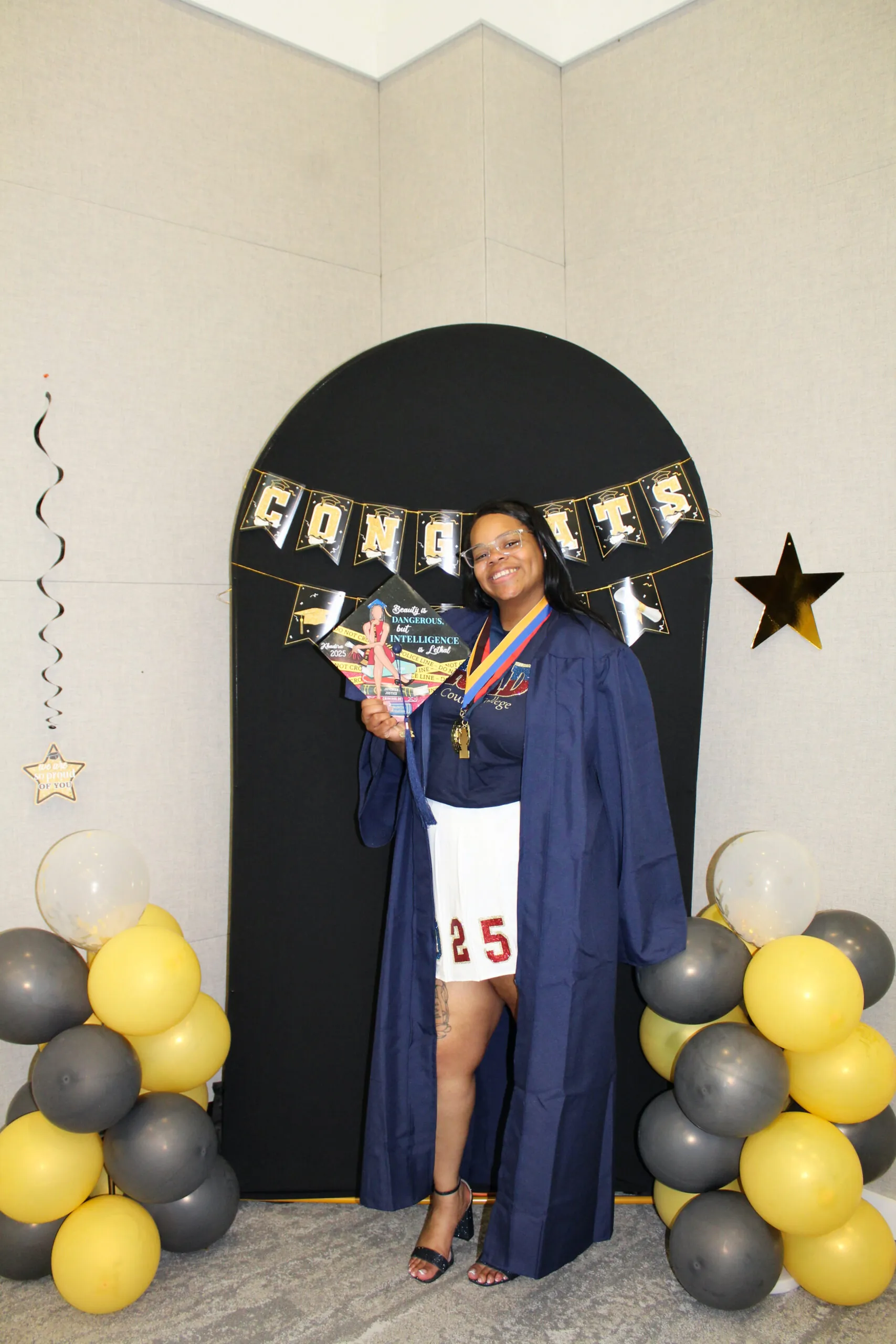 A student posing in graduation regalia