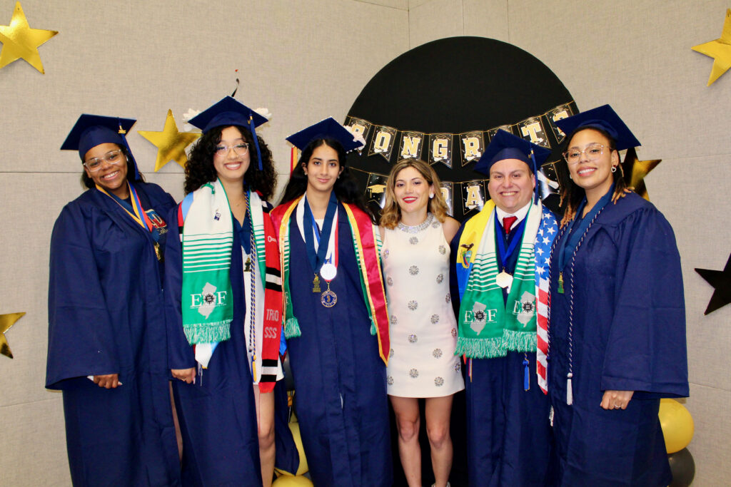 Group of EOF Scholars in their caps, gowns, and regalia at graduation.