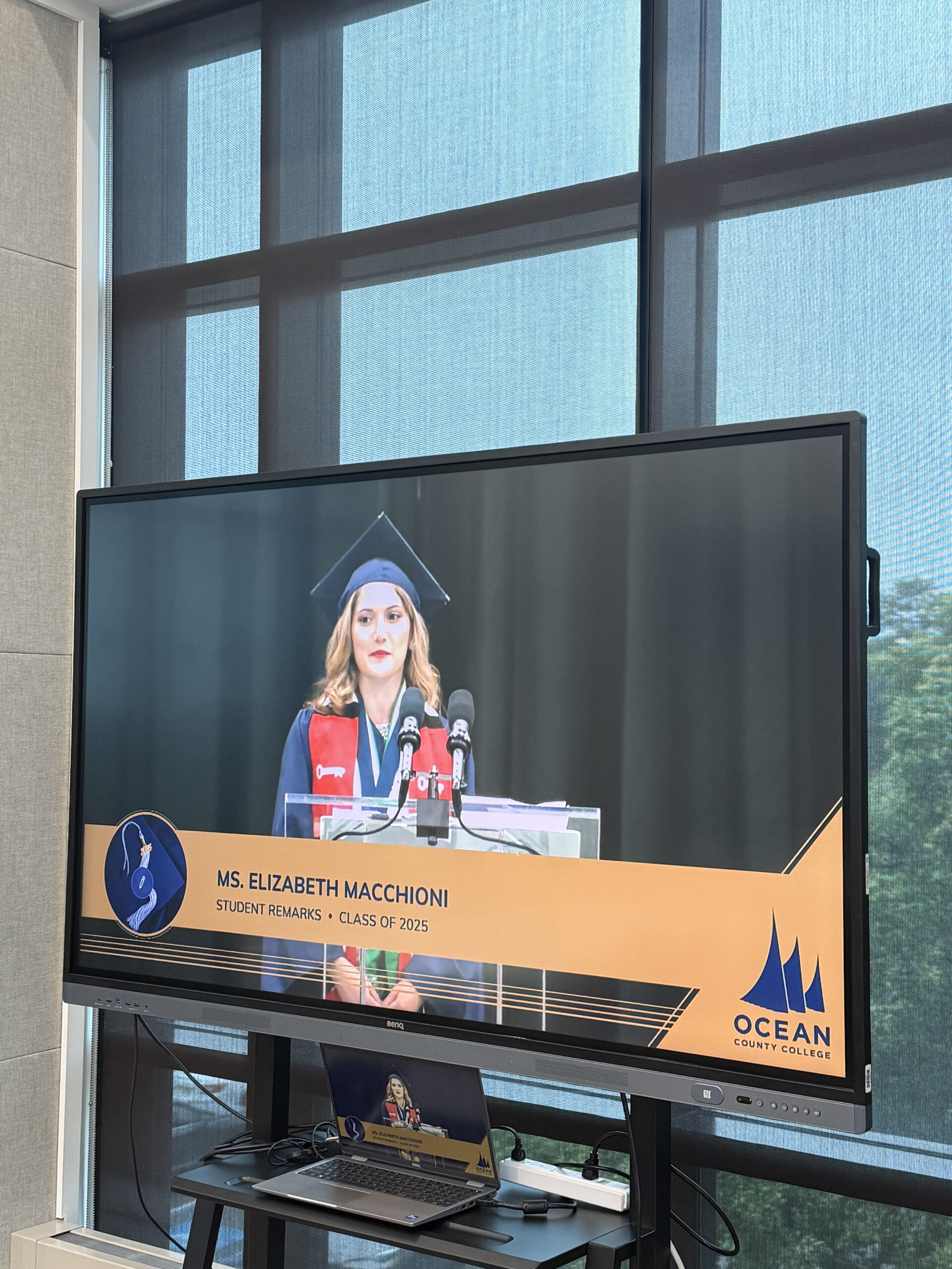 A TV displaying a livestream of the OCC commencement ceremony