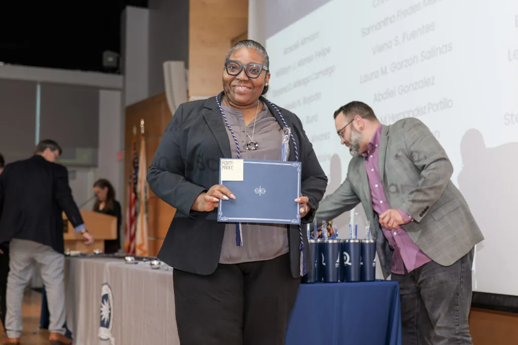 student on stage holding certificate