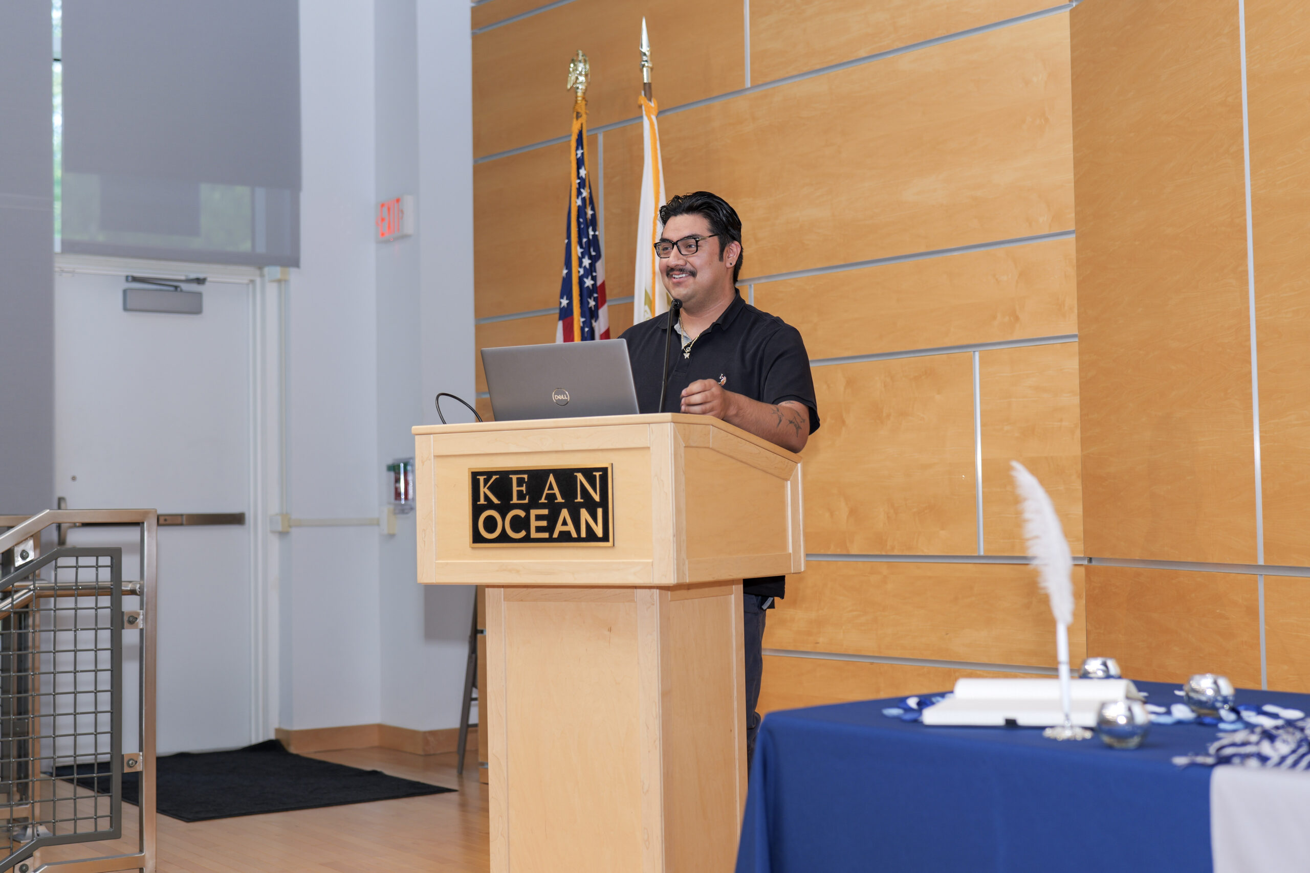 EOF student standing on stage in front of a podium delivering a speech, 