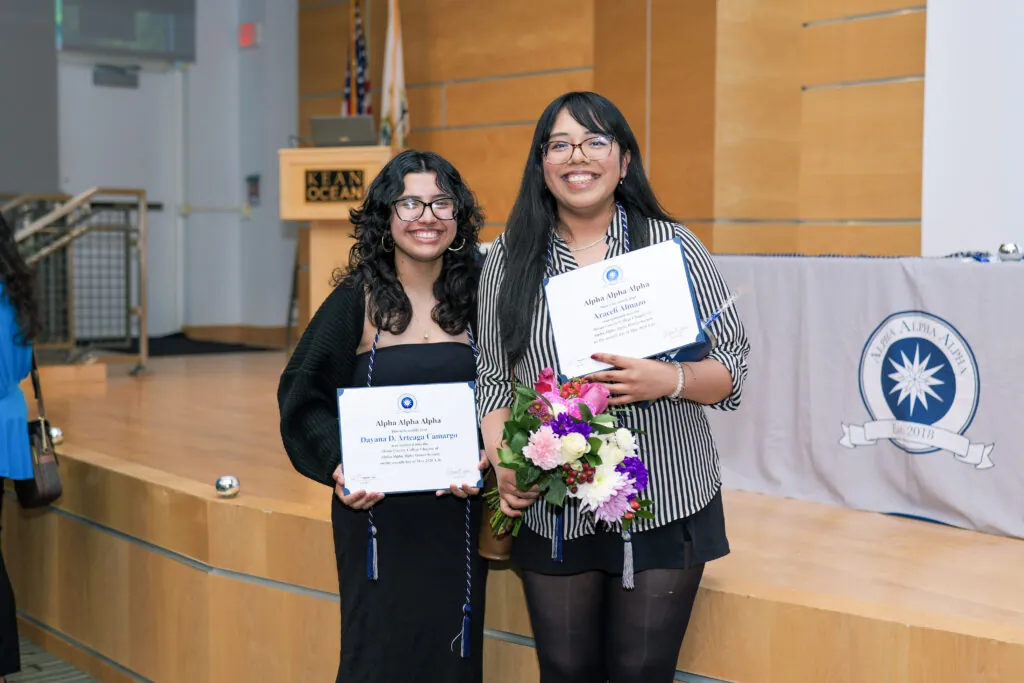 Two students posing with their induction items
