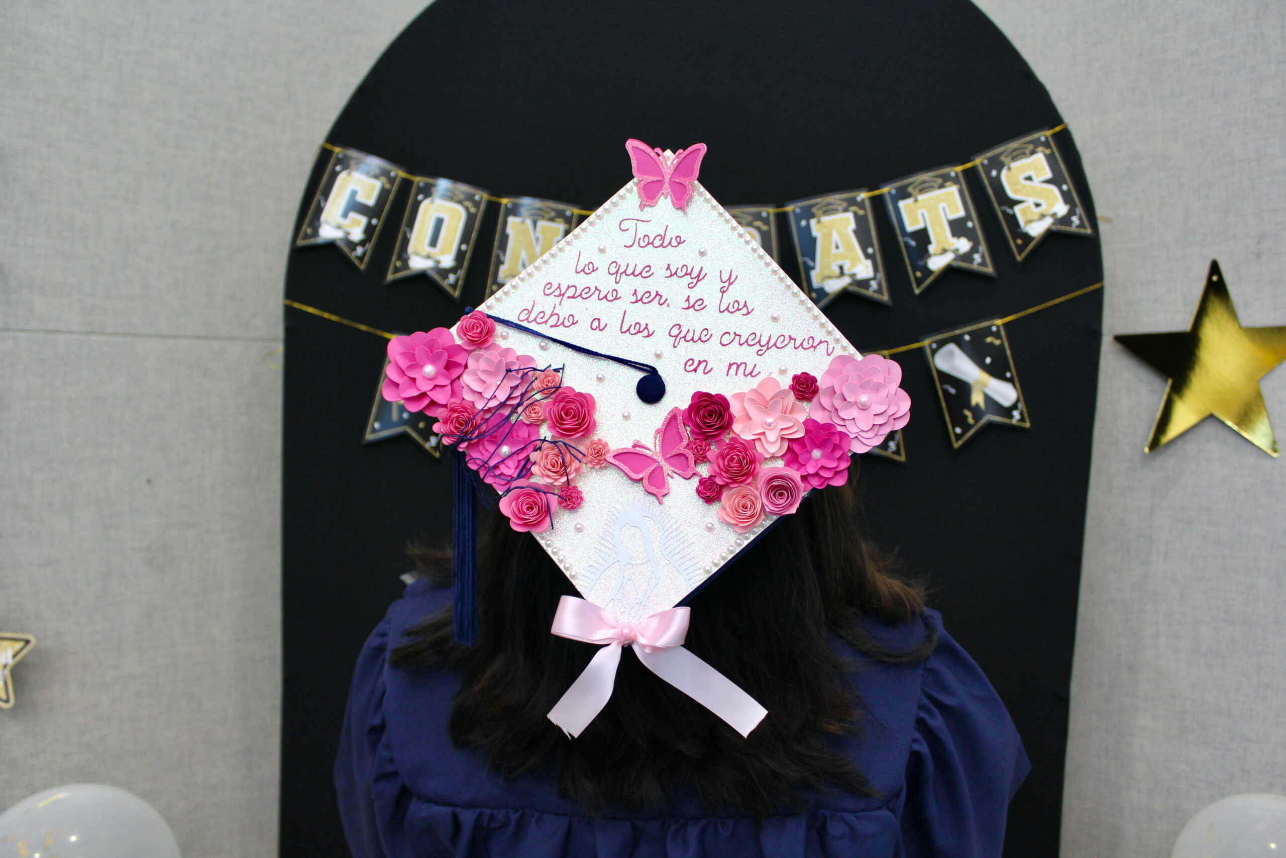 decorated graduation cap with pink flowers and butterflies. 