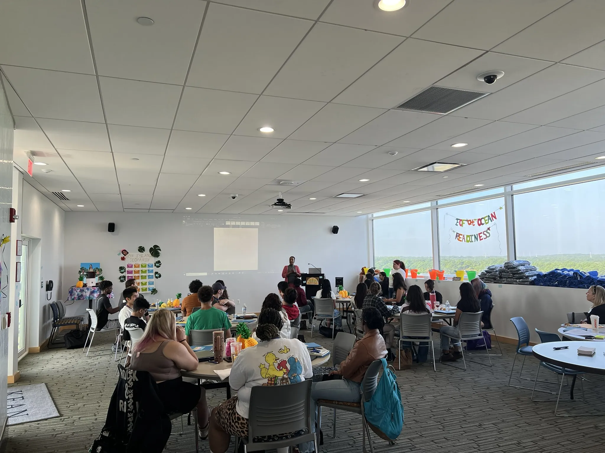 Students sitting at tables watching a presentation. 