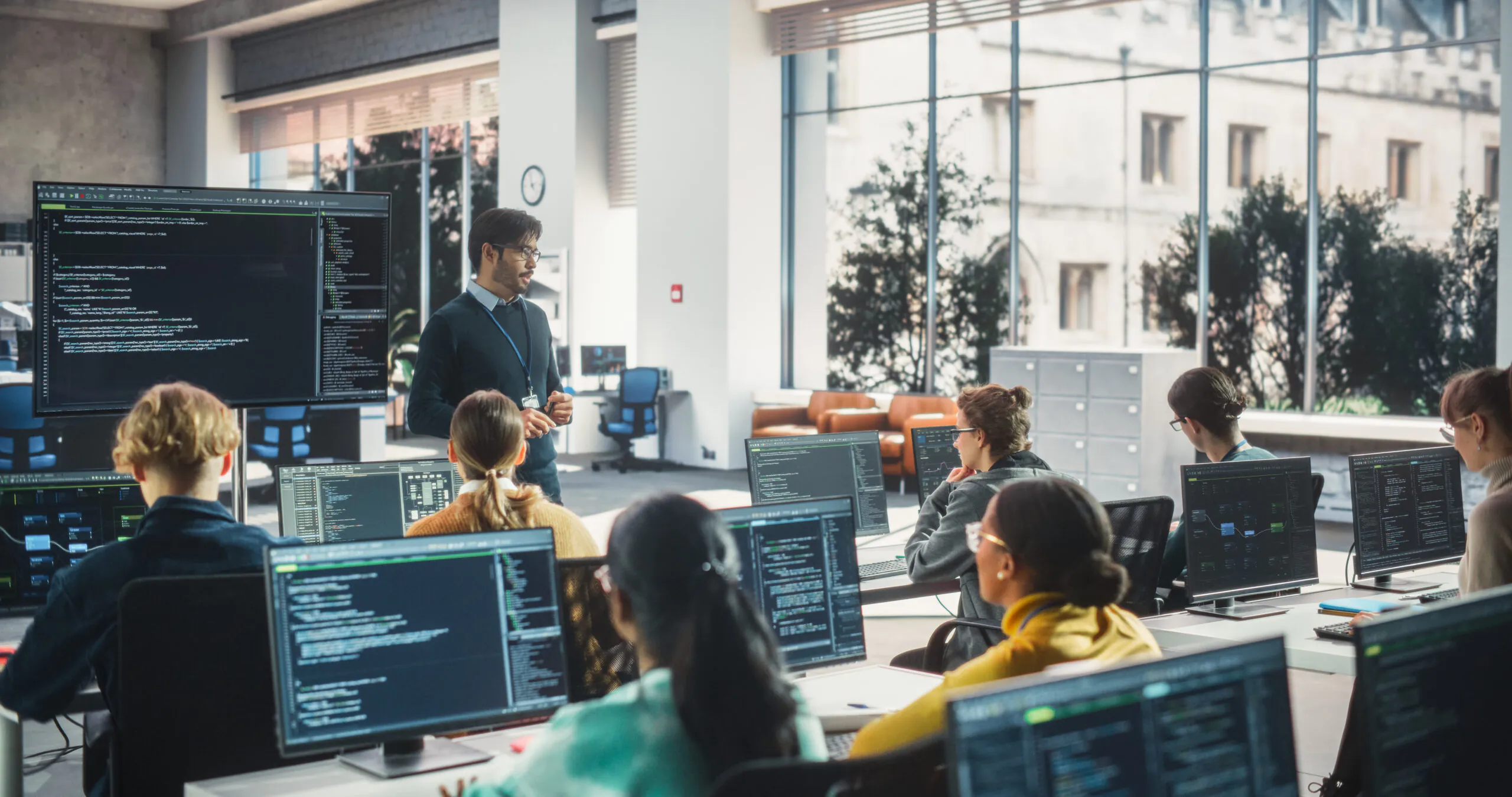 Students sitting at computers listening to a professor