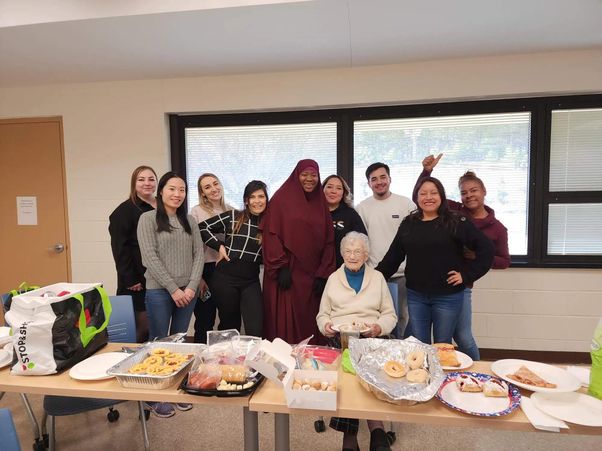 ESL students gathered at a table for a celebration