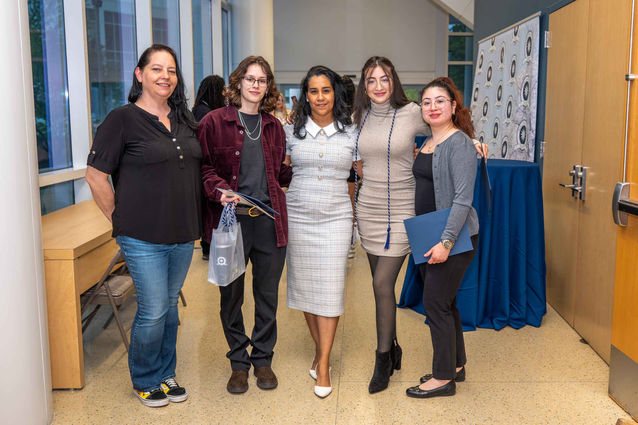 group of five women posing together