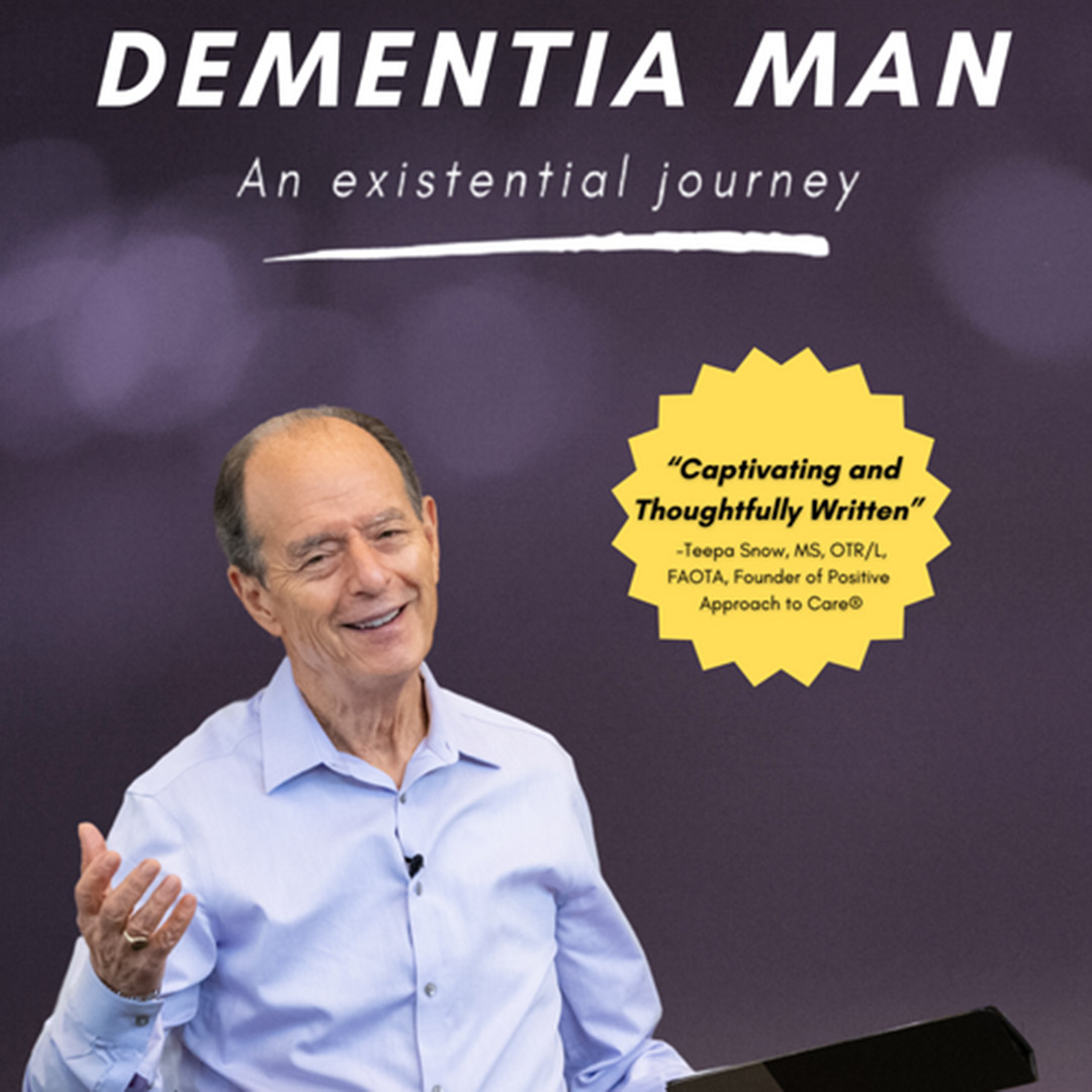A smiling man in a light blue shirt gestures with his left hand in front of a purple backdrop featuring "DEMENTIA MAN" and a quote highlighted in a yellow starburst.