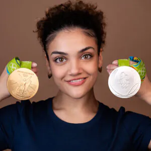 A person holding a gold and a silver Olympic medal.